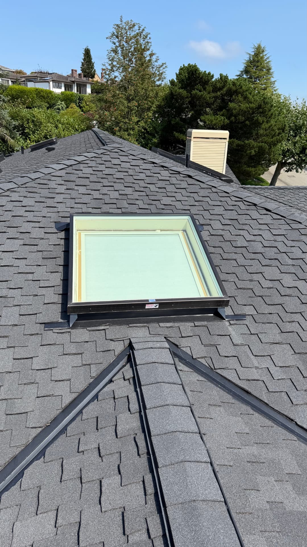 New skylight flashed into a charcoal architectural shingle roof in the Greater Seattle area