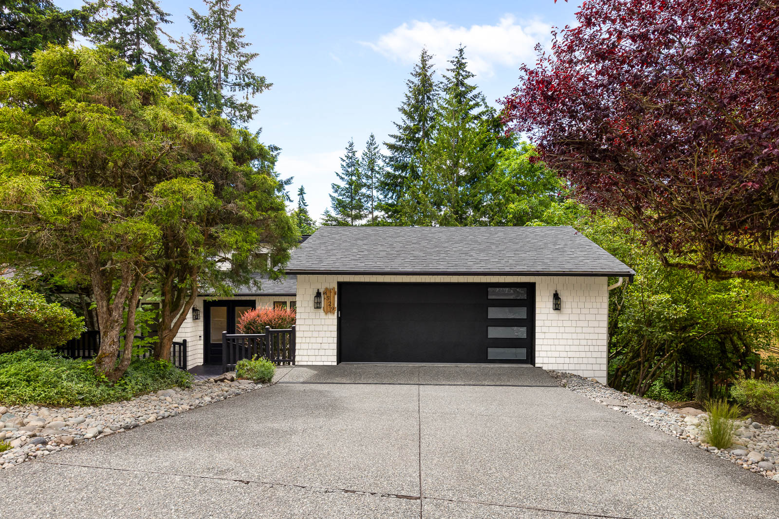 Street view of a home with a new charcoal shingle roof installed by GripGo Roofing