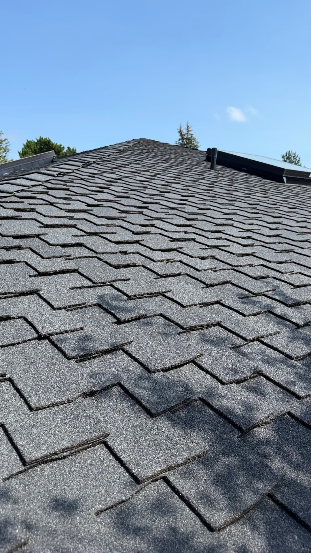 Close-up of new architectural shingles running up to the ridge